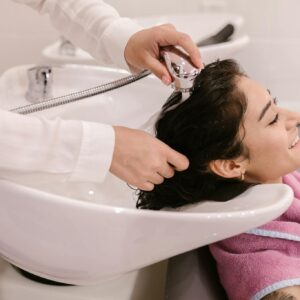 A young woman enjoys a relaxing hair wash at a modern beauty salon.